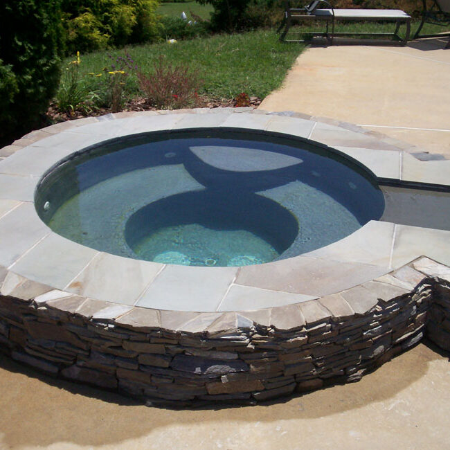 Poolside jacuzzi garden tub with mortared Pennsylvania stacked bluestone thin veneer enclosure with capstones for sitting