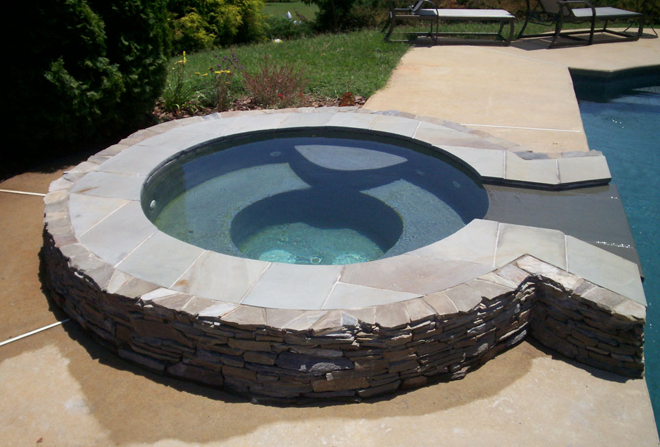 Poolside jacuzzi garden tub with mortared Pennsylvania stacked bluestone thin veneer enclosure with capstones for sitting