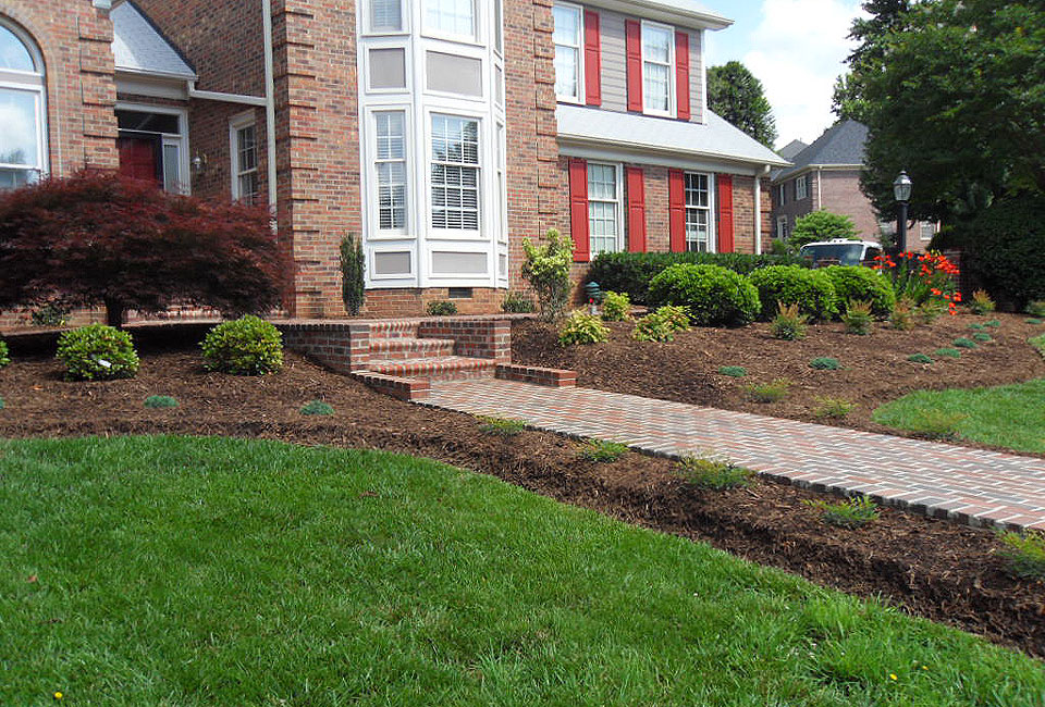 Front Yard Brick Walkway Border Beds softening Square Brick Structures with Layered Shrubbery Groupings & Specimen Plantings & 'Bloodgood' Japanese Maple Tree in Aged Hardwood Mulch