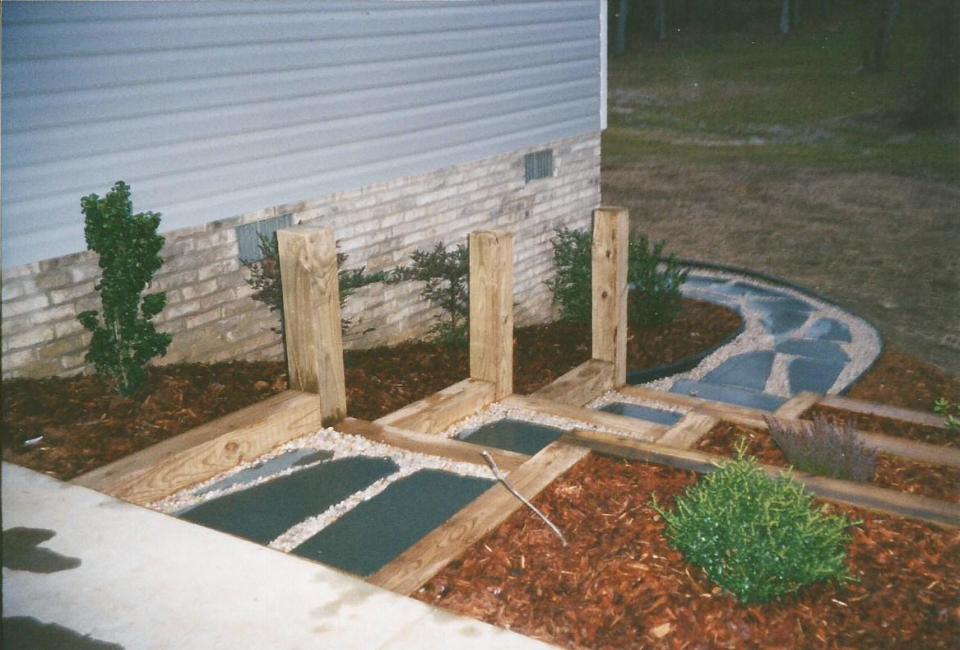 Timber Platform Stairs w/ Posts & Carla Bluestone Flooring set in White River Rock through Multi-Level Retaining Walls w/ Mulched Shrubbery Beds leading into Flagstone Walkway w/ Black Vinyl Borders