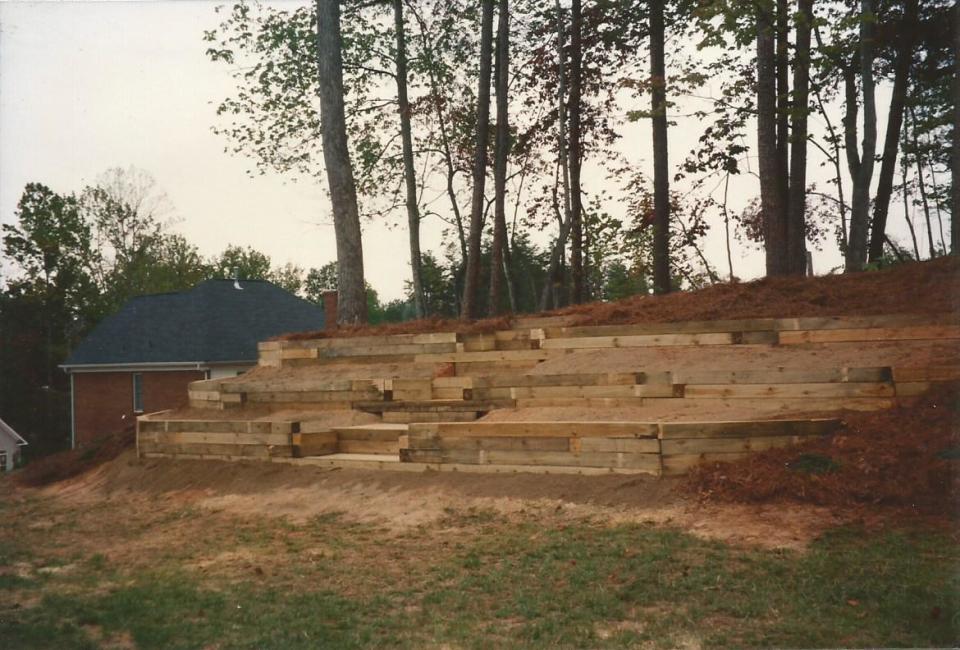Pressure Treated Landscape Timber Retaining Walls Terracing Back Yard Hillside into Four Levels w/ Decking Boards as Flooring for Stairs