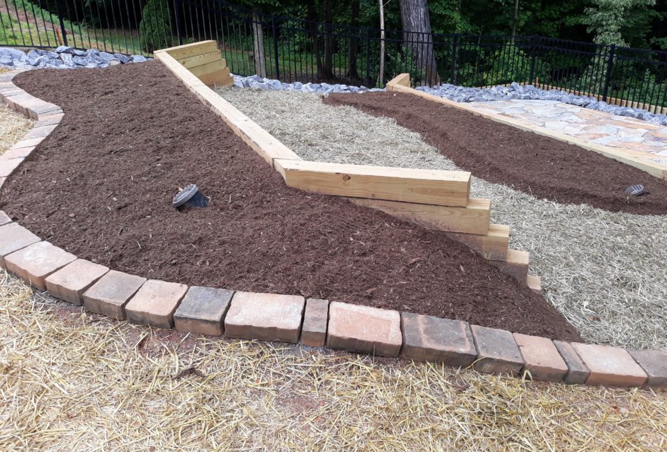 Terraced Backyard Landscape w/ 2 Pressure Treated Timber Retaining Walls, Belgard Paver Upper Border & Lighting w/ Mojave Thick or Velvet Gray Flagstone Patio w/ Catch Basin Drainage System Surrounded by Aged Hardwood Mulch & Dry Creek Beds